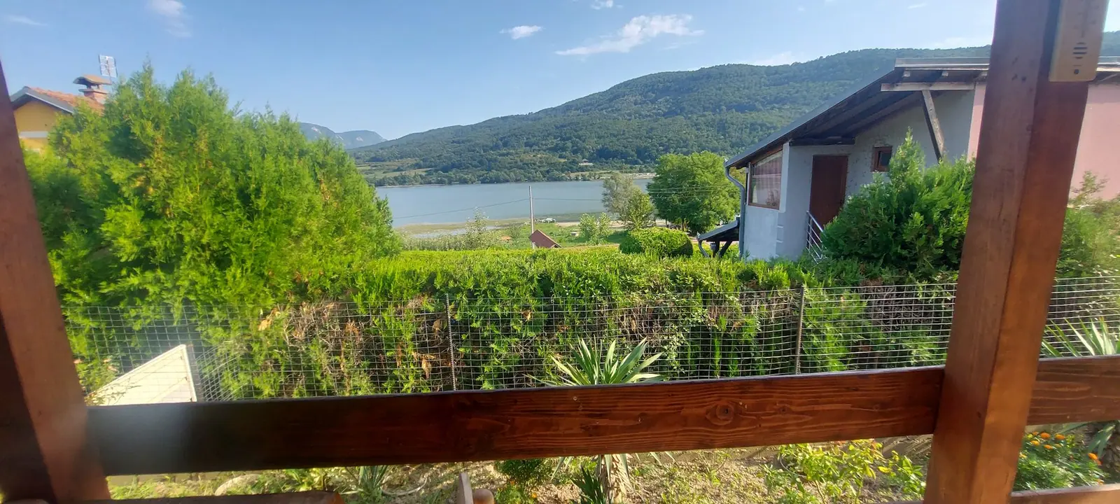 Pogled na jezero s terase kroz drvenu pergolu